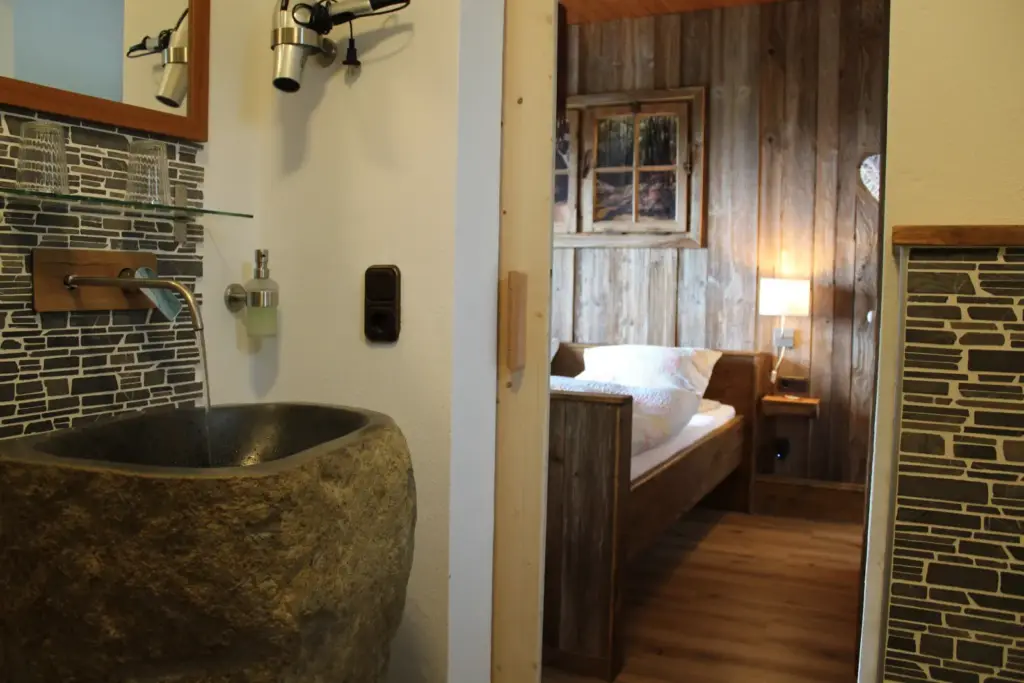 waldidyll natur badezimmer steinwaschbecken chalet 202602